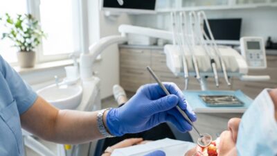 Стоматолог осматривает зубы пациента в современной клинике для выявления кариеса